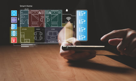People hand using smartphone or computer laptop to access smart home application from internet wireless connection to control and monitoring smart device inside of the house. Internet of things.の写真素材
