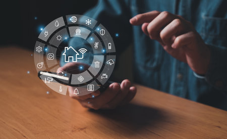 People hand using smartphone or computer laptop to access smart home application from internet wireless connection to control and monitoring smart device inside of the house. Internet of things.の写真素材