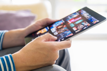 Selective focus at men hand and digital tablet. Young Adult Asian man holding tablet device while...
