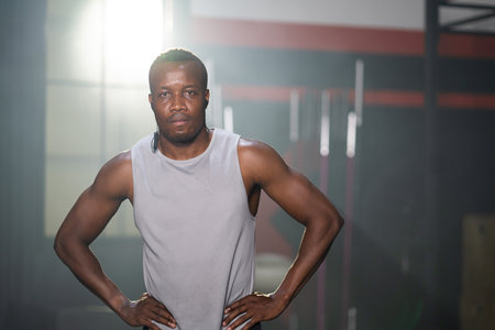 Selective focus at African men wearing sport cloth with smile inside of the gym before exercise and weight lifting inside fitness gym to workout for physical body strength and firm arms muscleの写真素材