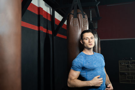 Young handsome Caucasian men with strong muscle in sport cloth standing inside of fitness gym for practice boxing and cardio sport activity training. Good body posture, bodybuilding sport.の写真素材