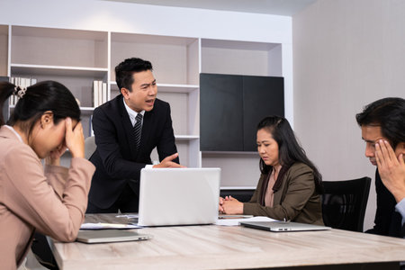 Asian men manager scold and angry with their employee inside of office meeting room with upset and stress worker. Business failure. Problem in working office issue.の写真素材