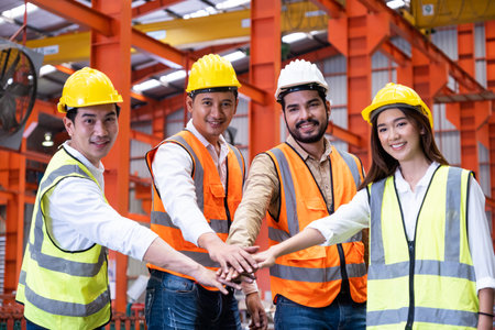 Asian people group of multi mix race worker with supervisor holding hand to cheer up and encourage before working at industrial factory site. Teamwork, labor brainstorm or group working concept.の写真素材