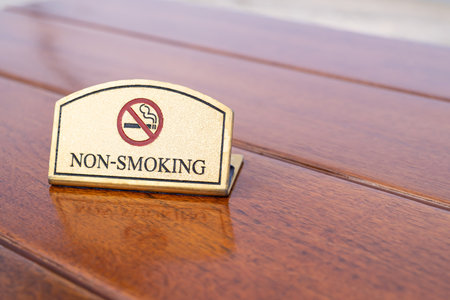Luxury no smoking sign made of golden brass place on midnight blue painted concrete wall. Prohibit public area for cigarette smoker which unhealthy for other people. with copy space for textの写真素材