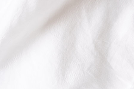Close up shot at white shirt fabric that show the details of cotton and wool of the cloth. with shade of light and shadow, with copy space for text. Ideal for background or wallpaper.の写真素材