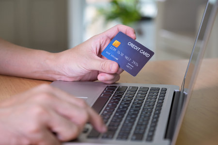 Men hand holding credit card and type payment information on keyboard for order online shopping. Internet technology and Digital market place E-Commerce lifestyle concept, Purchase transaction.の写真素材