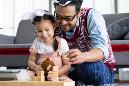 Asian Father and daughter, smile, hug and playing with doll and toy together inside of the living room. Happy moment with male parent, family relationship.の写真素材