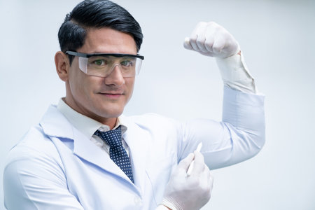 Portrait shot of Caucasian male scientist that feeling confident and show muscle on his arm as expression of his confident and expertise to experiment in laboratory. Positive working attitude.の写真素材