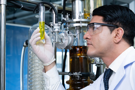 Selective focus at lab beaker, test tube while scientist study and examine with chemical or essential oil for medicine inside test laboratory. Chemical engineer work process with copy space for text.の写真素材