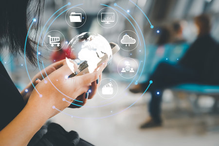 Selective focus at women hand holding mobile smartphone to activate global data roaming package or surfing for internet connection while travel in the airport with futuristic icon.の写真素材
