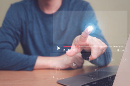 Selective focus at finger that push on press play button for start online entertainment for on demand video streaming service that online over internet which include movie or music.の写真素材