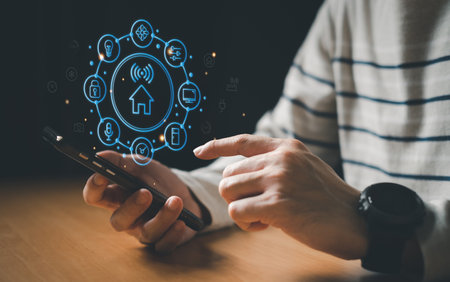 People hand using smartphone or computer laptop to access smart home application from internet wireless connection to control and monitoring smart device inside of the house. Internet of thingsの写真素材