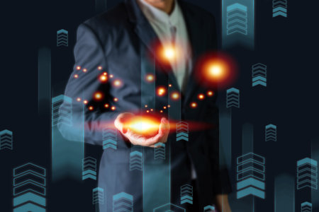 Businessman holding virtual hologram with cityscape background. Business and technology conceptの写真素材