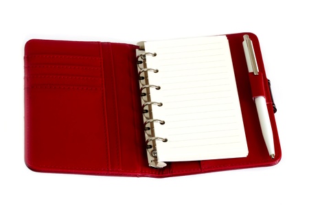 Red notebook and a pen with white paperの写真素材