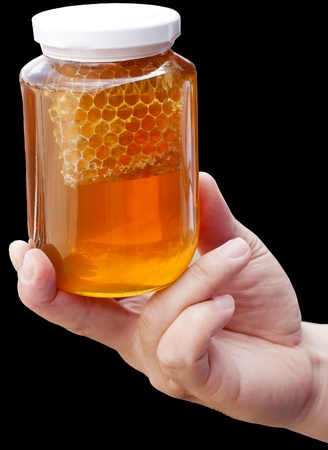 Natural floral honey in hand isolated on a black background の写真素材