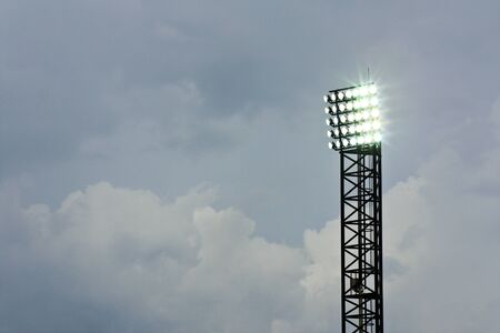 Spotlight of football stadium is lighting up beautiful background cloudの写真素材