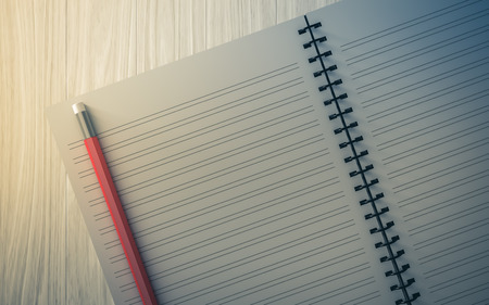 pencil on checked notebook on wood background, stationary objectの写真素材