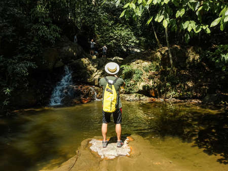 Pahang, Malaysia - May 2, 2016 : A tourist standing in the middle of a calm river taking photographs of the rainforest at Belum National Park Malaysiaのeditorial素材