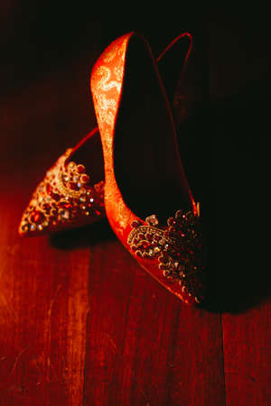 Close up on the intricate details of a red color traditional Chinese wedding shoeの写真素材