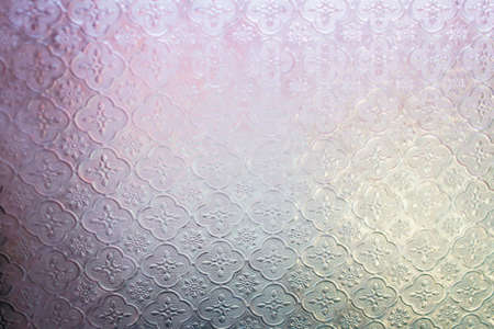 A decorative stain glass with intricate designs against a colorful backgroundの写真素材