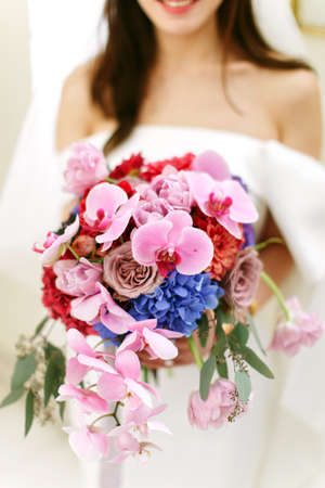Close up focus on the flower bouquet being held by an anonymous bride (face not seen) during a weddingの写真素材