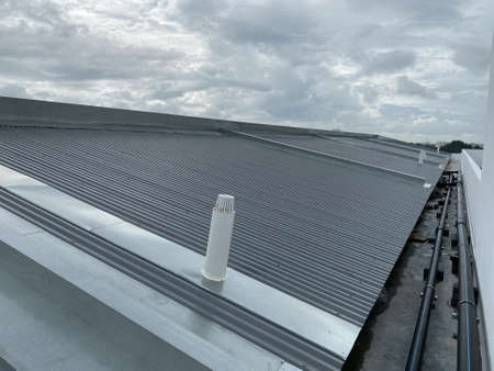 corrugated metal deck roof system with galvanised iron sheets installed on a buildingの写真素材
