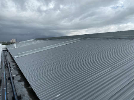 corrugated metal deck roof system with galvanised iron sheets installed on a buildingの写真素材