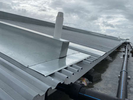 corrugated metal deck roof system with galvanised iron sheets installed on a buildingの写真素材