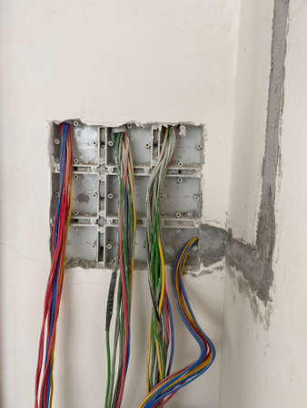 Wires coming out of the wall of a building in the midst of construction