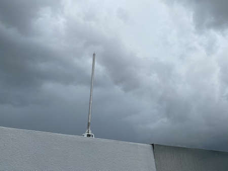 View of a lighting rod placed on top of a building during a stormy skyの写真素材