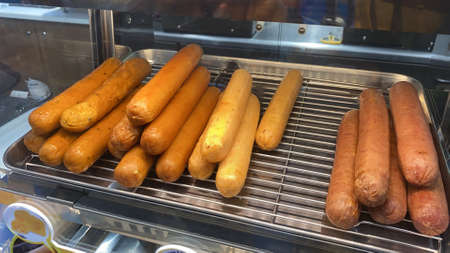 View of cooked sausages sold in a hot oven at a convenience storeの写真素材