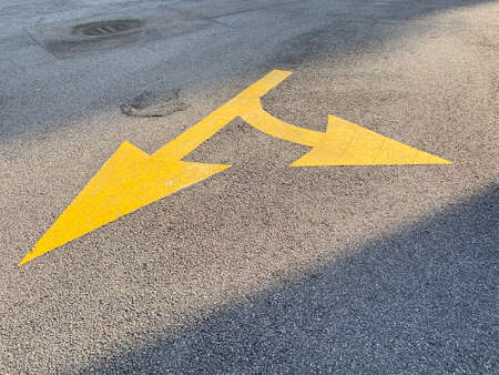View of a yellow directional road arrow painted with thermoplastic material