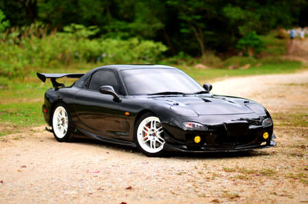 Penang, Malaysia - January 12, 2021 : View of a black Mazda RX-7 original specsification with trees in the background at Gelugor, Penangのeditorial素材