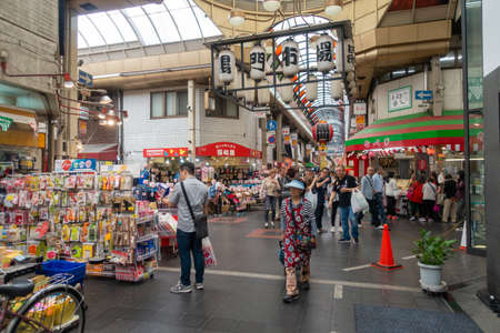 Shoppers at  Sennichimae Doguyasuji Shopping Street in Osaka. It is a very popular and famous shopping street  or shotengai amongst tourists in Japanのeditorial素材