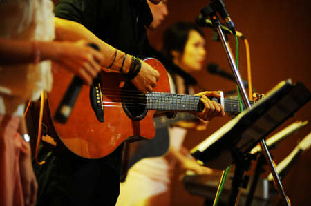 Close up of a person playing a guitar during a private function at Batu Feringghi
