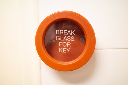 A red colored emergency break glass panel in case of a fire emergency. It is installed in all buildingsの写真素材