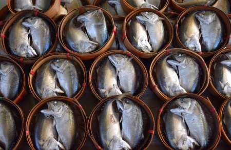 Pairs of chub mackerel in tiny baskets in the marketの素材