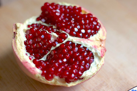 half of a pomegranate on the wooden tableの写真素材