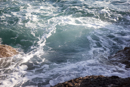 Waves breaking on the rocks in the sea, closeup of photoの写真素材