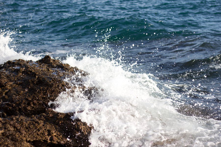 Sea waves crashing on the rocks. Shallow depth of field.の写真素材