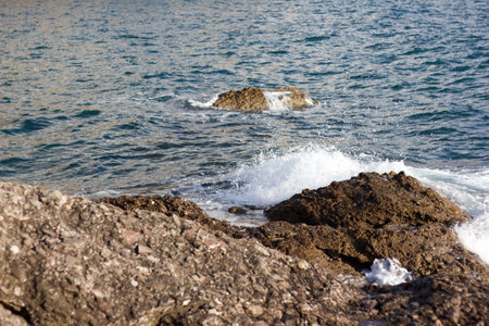 Rocky shore of the Mediterranean Sea with waves crashing against the rocksの写真素材