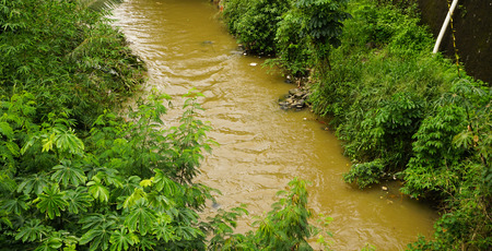 A brown coloured dirty river in Bogor, Indonesiaの写真素材