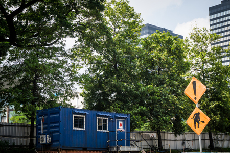blue container house as office or house with green tree as background and big building