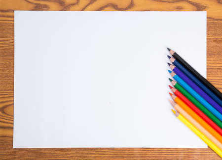 Blank white paper and color pencil on wooden table