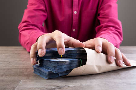Businessman receive money in the envelope offered in file - anti bribery and corruption conceptsの写真素材