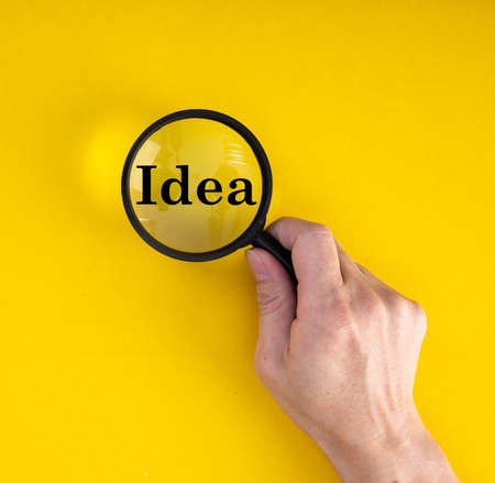 Creative idea and innovation concept with magnifier on yellow backgroundの写真素材