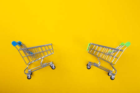 close-up of shopping trolley on yellow background with some copy spaceの写真素材