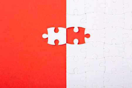 Blank white puzzle pieces on red background, flat lay. Space for textの写真素材