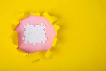 ripped  paper with uncompleted white puzzle.の写真素材