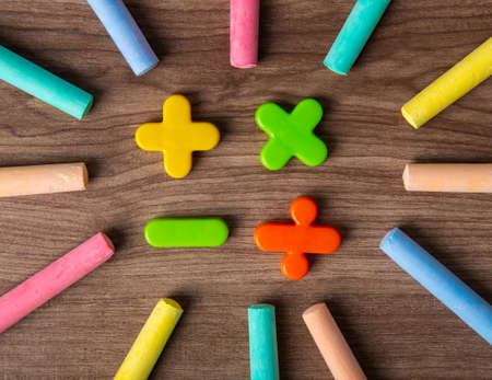 Mathematical math symbols with color chalks on wooden background